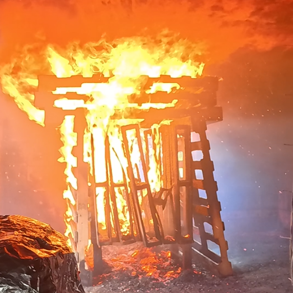 Wooden pallets burning inside the training structure during a firefighting training experiment.