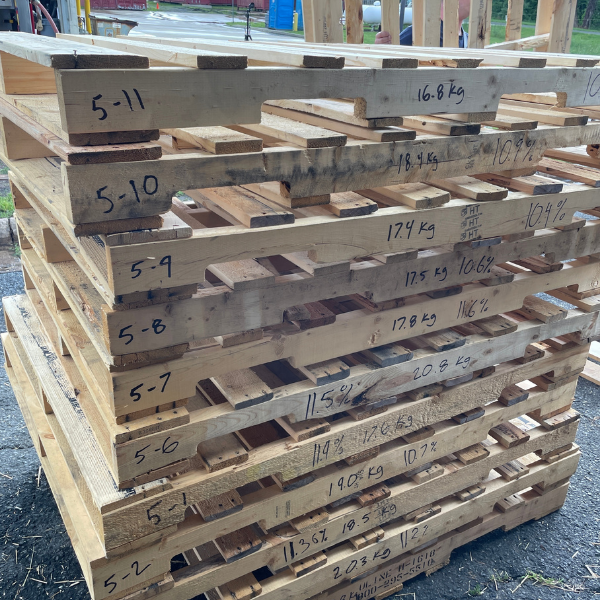 Stack of labeled wooden pallets prepared for use in firefighting training experiments that measure fuel load and its impact on thermal conditions.