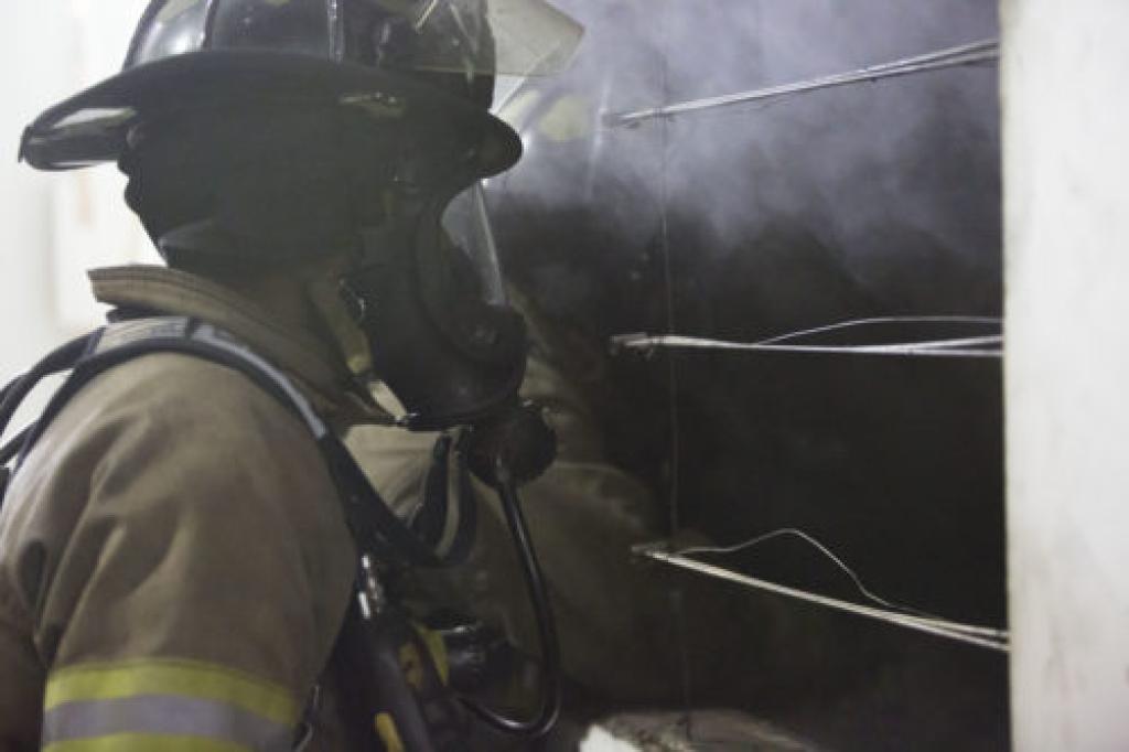 Firefighter looking through window and smoke
