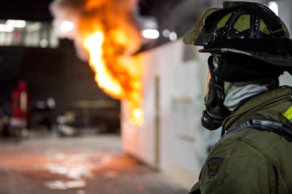 Silhouette fireman in front of flaming training structure