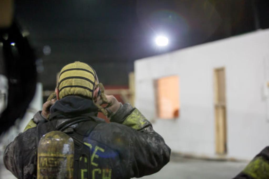 Firefighter standing in front of burning training building