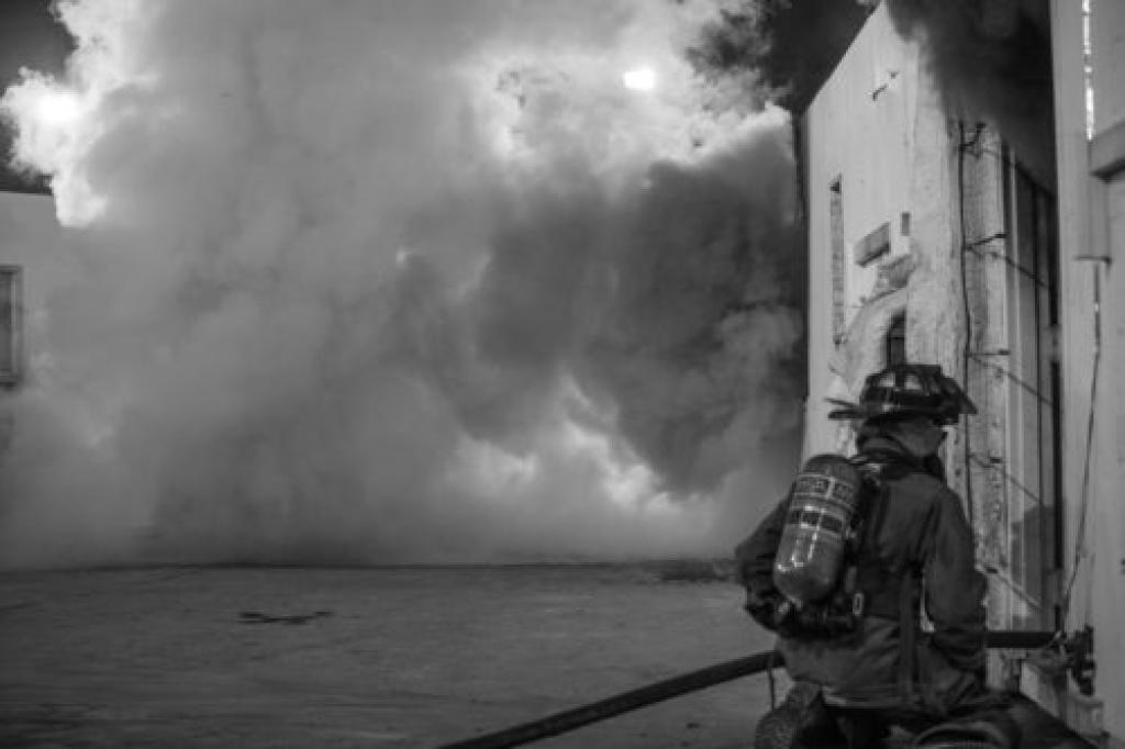 black and white training with firefighter entering building
