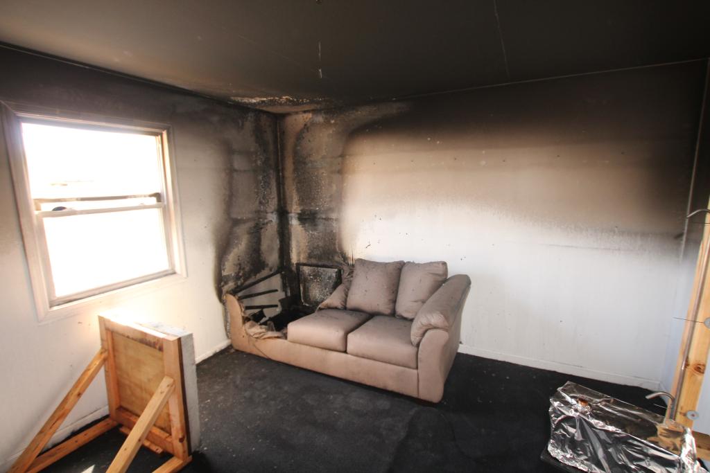 Couch in the corner of a room after a fire