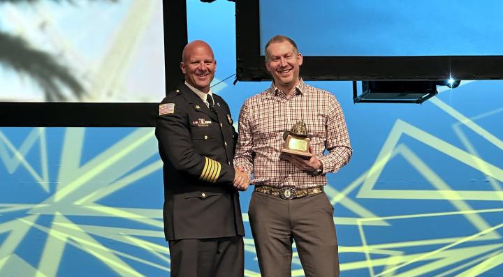 Craig Weinschenk presented with award by IAFC president Josh Waldo