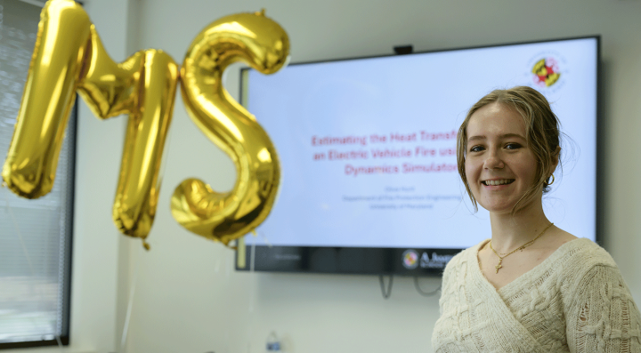 Olivita presenting thesis on electric vehicle fire modeling with MS balloons in background