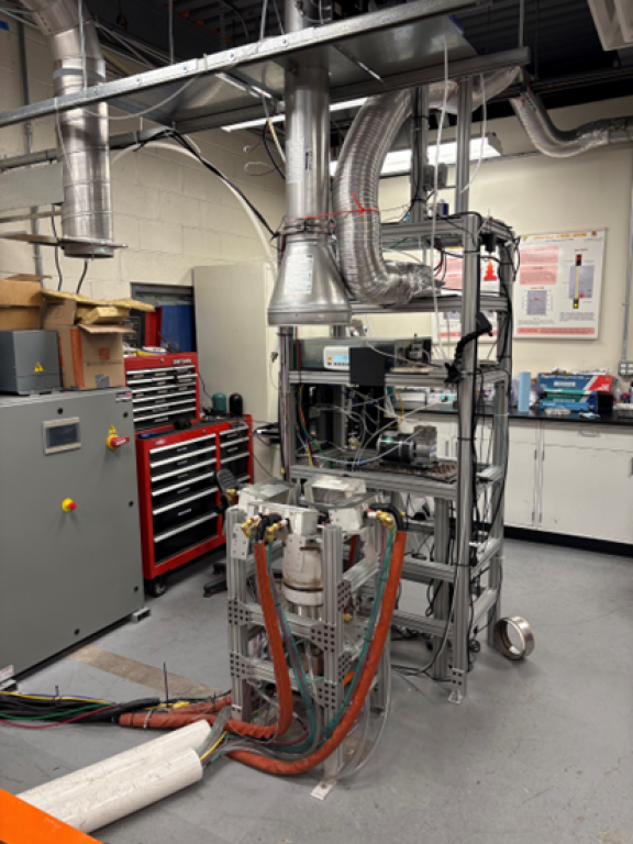 The image shows the Fire Propagation Apparatus (FPA) utilized at the University of Maryland. The FPA provides FSRI scientists highly reproducible bench-scale experiments which mimic true fire conditions to the material, and it is easily modified to sample fire effluent.