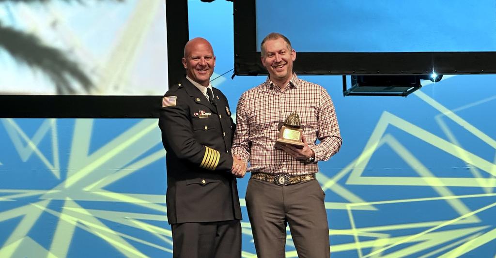 Craig Weinschenk presented with award by IAFC president Josh Waldo