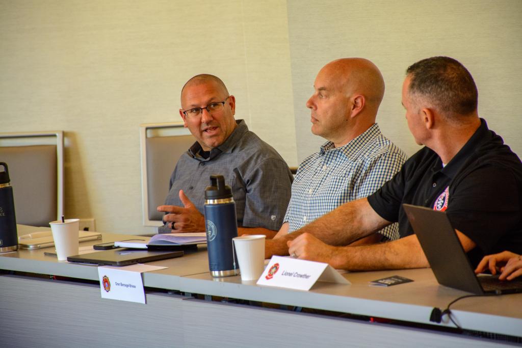 TAC members seated around a conference table discussing firefighting training materials
