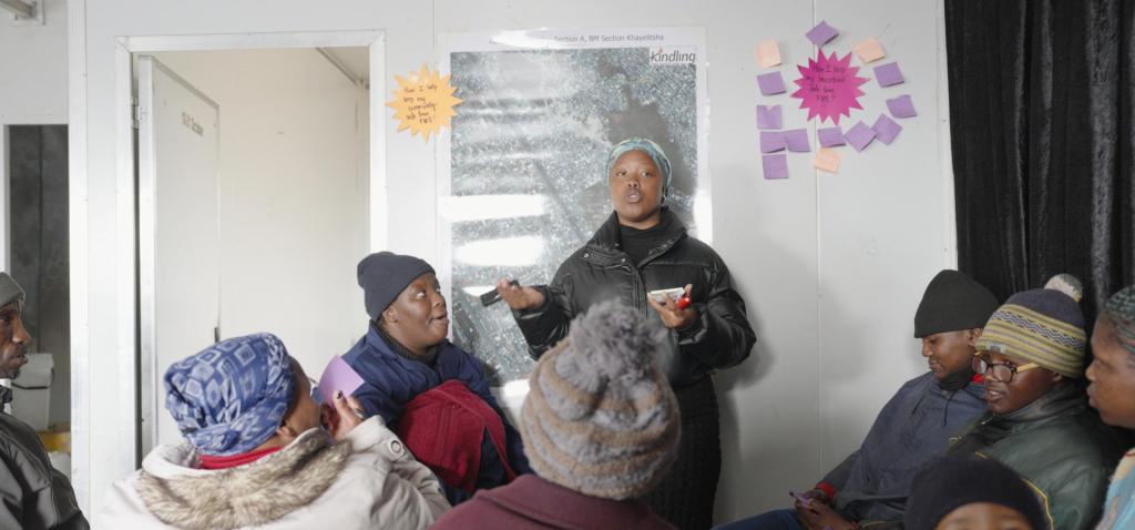 Several residents gather for discussion around a map and generate ideas on notecards
