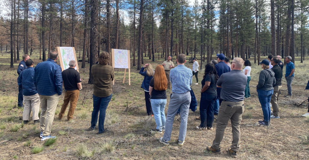 Flat Fire staff ride attendees gather around area maps as state and federal officials discuss fire preparedness