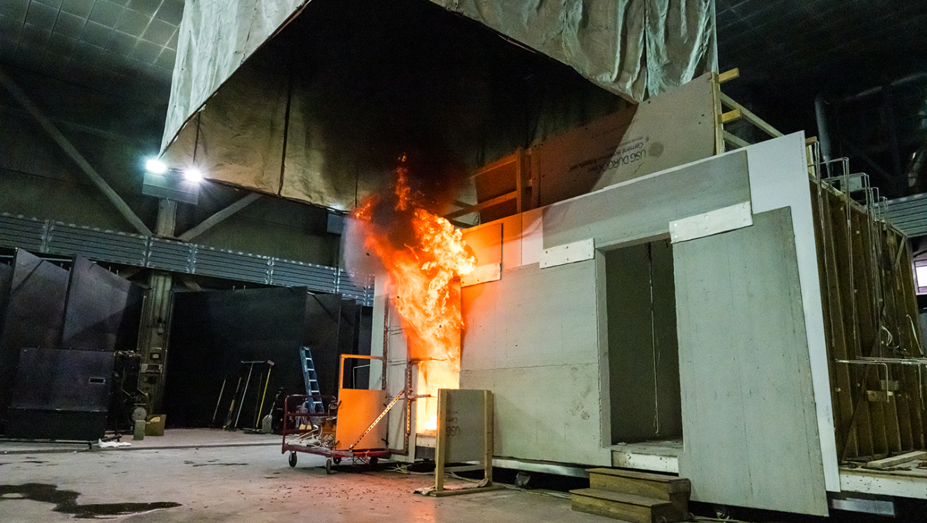 A double-room compartment being utilized in an experiment test where the left room is undergoing flashover.