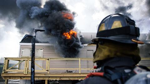 Firefighter observes experiments that inform the development of search and rescue tactics in residential structures