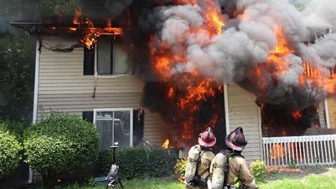 Firefighters conducting size-up operations during a multistory residential structure fire