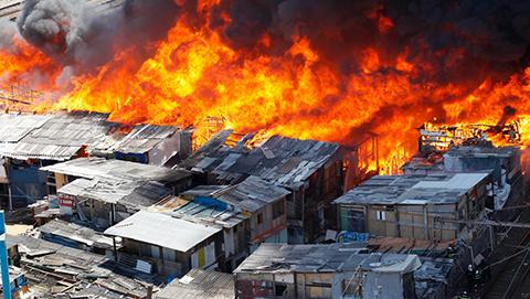 Fire spreads through an informal settlement