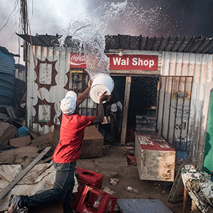 Residents of an informal settlement try to fight a fire on their own with limited resources