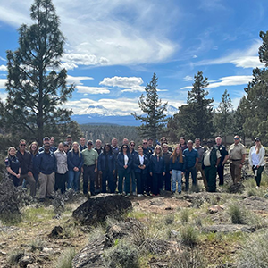 WUI advisory committee meeting attendees stand near the footprint of the Flat Fire