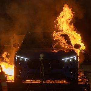 An electric vehicle engulfed in flames during a controlled EV battery fire experiment